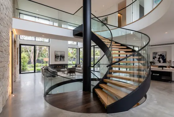 Luxuriöse Spindeltreppe mit schwarzer Stahlspindel und rahmenlosem Glasgeländer